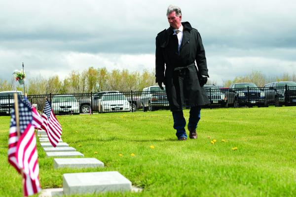 A Memorial Day visitor at the Ennis Cemetery reads the gravestones before the ceremony Monday morning, May 27. (H. Kearse photos)