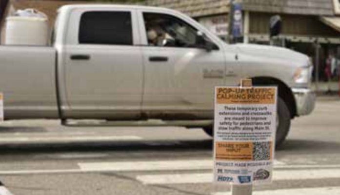 The traffic calming study displays signs about the online survey to share input. PHOTO BY HANNAH KEARSE