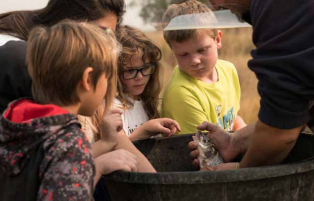Montana Fish, Wildlife and Parks Conservation Technician Lucas Bateman shows Twin Bridges’ students a whitefish during Kids’ River Resource Day at the Hamilton Ranch in Twin Bridges Sept. 17. PHOTO BY HANNAH KEARSE