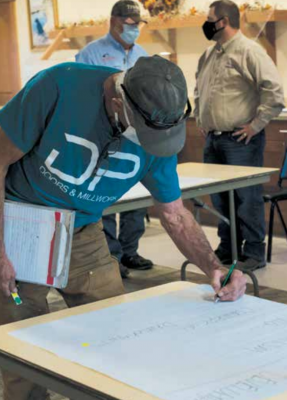 Brad Schwend votes for the town to focus on economic development during the growth policy and capital improvement plan public meeting at the Sheridan Senior Center Oct. 12. PHOTO BY HANNAH KEARSE