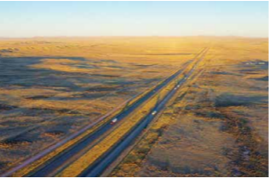 Parts of Interstate 80, which forms a nearly impermeable wildlife barrier, are included on a list of priority projects the Wyoming Department of Transportation and Game and Fish Department hope to retrofit with wildlife crossings. This aerial view looking east captures a sunset vista of Interstate 80 as it crosses the Great Divide Basin, in the heart of pronghorn winter range. Not far from here a motorcyclist died in August 2018 after colliding with an elk. PHOTO COURTESY WYOMING MIGRATION INITIATIVE