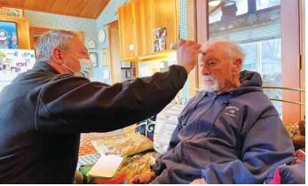 Madison Valley Medical Center EMT Corey Siders visits with 91-year-old Robert Kensinger in Ennis, Montana as part of the hospital’s community paramedicine program. Kensigner says these visits help him remain safely living in his home. PHOTO COURTESY AARON BOLTON, MONTANA PUBLIC RADIO