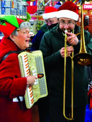 Led by Ennis music director Andrew Scruggs (right) carolers traversed up and down Main Street and even entered businesses like Shedhorn Sports to spread some holiday cheer.